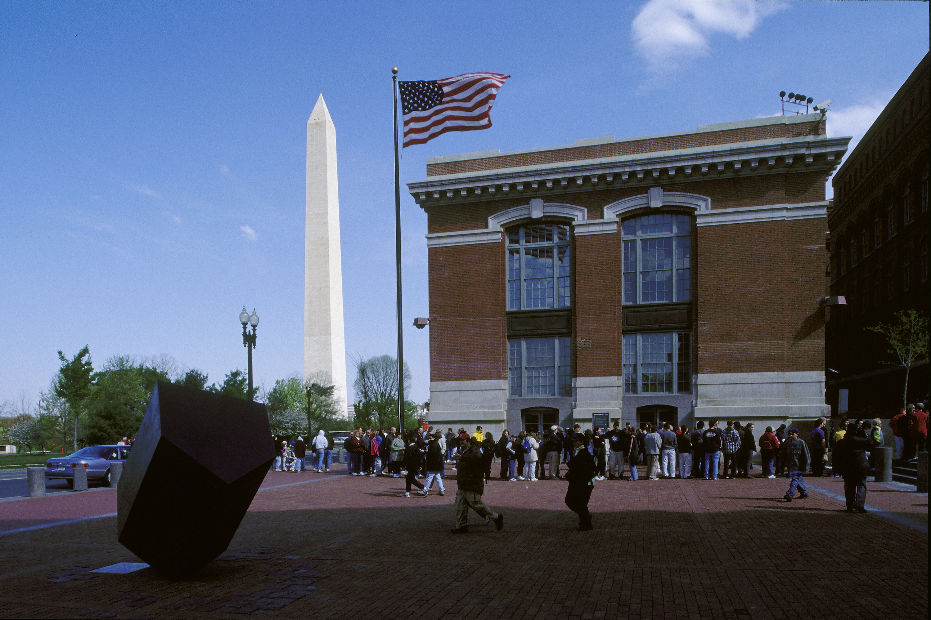 Visitors wait in line on the Eisenhower Plaza to enter the U.S. Holocaust Memorial Museum.  Behind them is the Washington Monument and the Ross Administration Building.