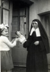 Claire and a nun play with a doll.