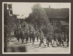 SA members and Hitler Youth march down the street in an unidentified German town.
