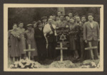 Jewish survivors gather for a memorial service by the site of a mass grave in an unidentified locale.