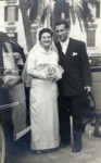Emma Di Capua and Stefan Honig pose next to an automobile on their wedding day.