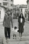 Felix and Charlotte Gelehrter walk down the streets of Bucharest with their son, Lou.
