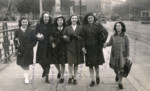 A group of friends walks down the street arm in arm in wartime Rome.
