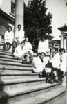 A Jewish Romanian woman poses on an outdoor stairwell with her medical school classmates.