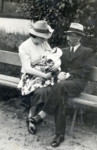 Adela and Moshe Alterman sit on a park bench with their baby daughter, Leah.