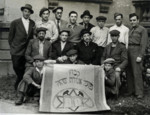 A group of men with an Agudat Israel Kibbutz flag in the Neu Freimann displaced persons camp.