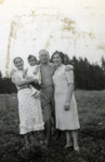 A Jewish family poses for an outdoor photograph.

Pictured are Braina and Modechai Intriligator with their baby, Chaya, and an unidentified woman on the right.