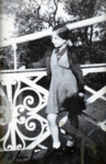 A Belgian Jewish girl leans against an intricate railing.