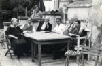 Friends and family gather around an outdoor table, on a terrace in Vienna.