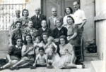 Group portrait of Jewish family members and neighbors after their expulsion from Sofia, in front of their house on Yumach street in Haskovo.