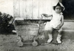 Miriam Graubart sits on a step next to her toy baby carriage, in the Pocking displaced persons camp.