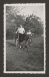 A Belgian Jewish child who lived in hiding during the war rides bikes with a neighbor who safeguarded his family photographs.