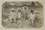 Karl and Robert Bloch-Bauer pose on the beach with two young girls, possibly cousins Mira and Bettina Bauer.