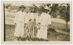 Three family members stand outside to pose for a portrait.