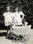 Miriam Meisels (right) poses with her sister Yehudit and a doll and carriage on her seventh birthday.