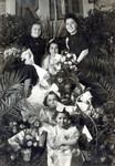 Women and girls attend the bride Chanka Smerler who is seated surrounded by flowers on her wedding day.