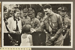 Adolf Hitler, surrounded by SA stormtroopers, greets girls during the annual Nazi Party congress in Braunschweig, Germany.