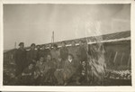 Group portrait of internees in the Gurs camp posing outside their barrack.