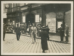 Men and women walk down a commercial street probably during the 18th Zionist Congress.