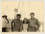 Two teenagers pose with crew member Teddy Vardi on the bridge of the SS Caserta.