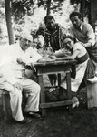 Members of the Weisz family gather for a drink in the woods.