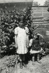 Agi (Agnes) Klein (right), the young daughter of Lili Suryani, poses with an older child.