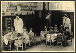 Children sit at tables to do an art project in a classroom in the Nos Petits Jewish kindergarten.