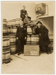 Four German-Jewish men pose next to wooden  barrels in the Bauer, Blum & Co.