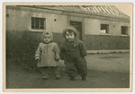 Jochewet Doba Lanzer and another toddler pose outside a building in the Ulm displaced persons camp.