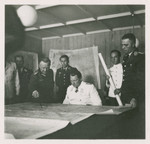 One side of a stereograph of Herman Goering studying a map with his generals.