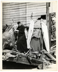 A Polish Catholic priest removes religious items (including a crucifix) from a destroyed church.