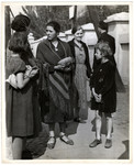 A group of Polish women and children gather on the street during the Siege of Warsaw - the woman in the center is holding a loaf of bread.