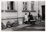 Men and women pile sand bags outside on the base of the American consulate in Warsaw to protect it from German bombs.