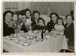 Mothers and toddlers gather around a festive table in the Schlachtensee displaced persons' camp.