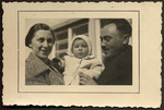 Close-up portrait of Yehuda and Ella Mandel holding their infant son, Manny.