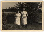 Two dental technician students stand in a garden in the Bergen-Belsen displaced persons camp.