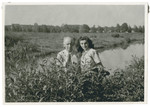 Vera Spitz poses by a stream or lake next to her father Bela.