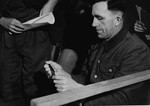 An unidentified defendant at the trial of 61 former camp personnel and prisoners from Mauthausen, sits in his place in the defendants' dock.