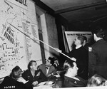 Father Jean Brinioul, a witness for the prosecution, indicates on a map where he was forced to work, during the trial of former camp personnel and prisoners from Buchenwald.