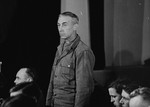 A defendant at the trial of 61 former camp personnel and prisoners from Mauthausen, stands in his place in the defendants' dock.