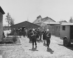 Under the guard of U.S. Military Police, the defendants assemble outside their barracks before entering the courtroom during the trial of former camp personnel and prisoners from Buchenwald.