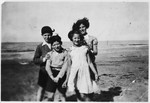 Four siblings pose together on a beach approximately half a year after arriving in England on a Kindertransport.