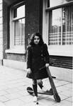 Ruth Franken poses next to her scooter on a sidewalk in Amsterdam.
