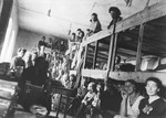Jewish women from Vienna sit on three-tiered wooden bunks in a barracks in the Opole Lubelskie ghetto.