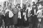 Group portrait of Jewish men, women and children on a street in the Opole Lubelskie ghetto.