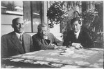Sexologist and sex reformer Magnus Hirschfeld (center) with his co-worker Bernhard Schapiro (1885-1966) and his Chinese (in exile) friend and pupil Tao Lee, sitting at a garden table, unknown place and date.