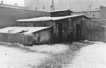 A Jew (perhaps a policeman) stands outside a low slung building in the Lodz ghetto.