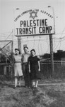 Three Jewish DPs pose in front of the entrance to the Palestine Transit Camp in Bremen, where they await transport to Palestine.