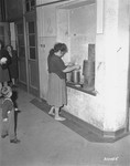 A Jewish woman cooks her dinner in what used to be a gun rack at the displaced persons camp in Wetzlar.