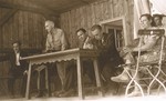 Saul Sorrin (third from left) shares the dais with the editor of the camp newspaper during a meeting at the Neu Freimann displaced persons camp.